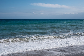 Mediterranean sea at sunset. Waves break on the sandy shore, sea foam. Natural background