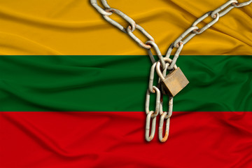 iron chain and lock on the silk national flag of lithuania with beautiful folds, the concept of a...