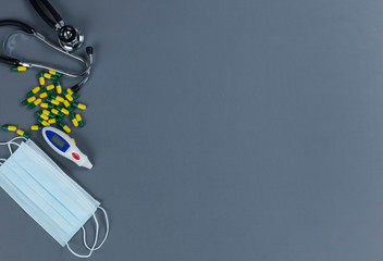 Medical equipment and pills on a gray background with copy space
