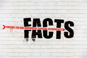 The word Facts with an arrow of conspiracy, fake news, disinformation, propaganda, alternative facts, painted on old white wall, facts being destroyed concept illustration