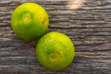 Fresh green oranges on an aged wooden background