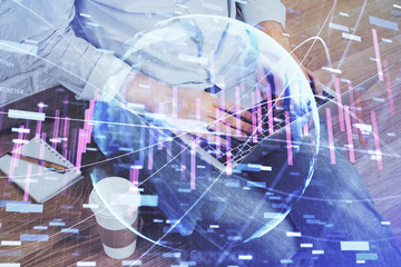 Forex graph with businessman working on computer in office on background. Concept of analysis. Double exposure.