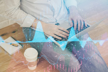 Forex graph with businessman working on computer in office on background. Concept of analysis. Double exposure.