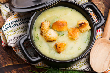 Creamy Jerusalem artichoke soup on wooden background