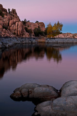 Fototapeta na wymiar The granite rock formations of the Granite Dells area of Watson Lake glow in the twilight of a fading southwestern sunset. Prescott, Arizona.