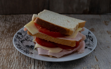 primer plano de un sándwich doble, con jamón, queso y tomate