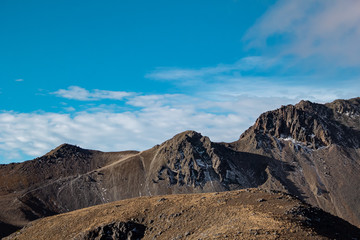 Paisaje montaña y volcán con cielo azul y nubes