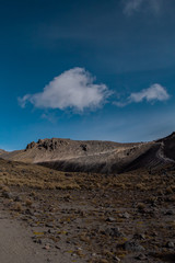 Fototapeta na wymiar Paisaje montaña y volcán con cielo azul y nubes