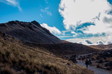 Paisaje montaña y volcán con cielo azul y nubes