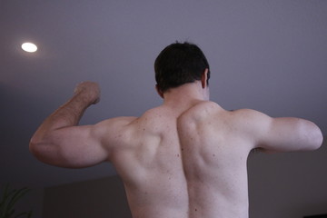 man flexing back in selfie type photo