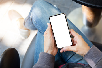 Mockup image blank white screen cell phone.woman hand holding texting using mobile on desk at coffee shop.background empty space for advertise text.people contact marketing business,technology