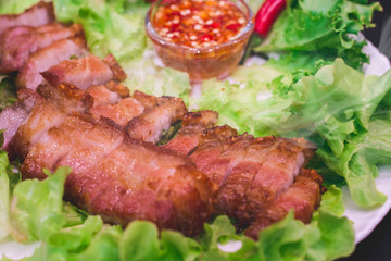Thai roasted crispy pork on lettuce with Thai Spicy Sauce, Close up view