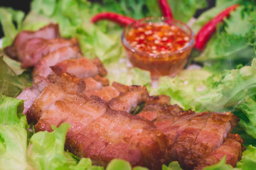 Thai roasted crispy pork on lettuce with Thai Spicy Sauce, Close up view