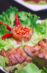 Thai roasted crispy pork on lettuce with Thai Spicy Sauce, Close up view