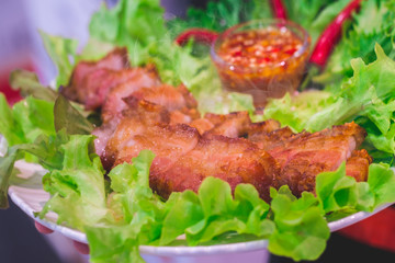 Thai roasted crispy pork on lettuce with Thai Spicy Sauce, Close up view