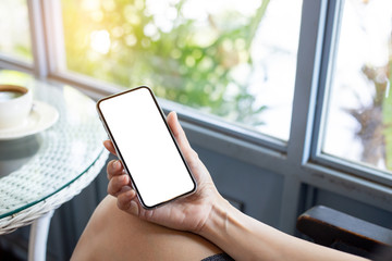 Mockup image blank white screen cell phone.woman hand holding texting using mobile on desk at coffee shop.background empty space for advertise text.people contact marketing business,technology