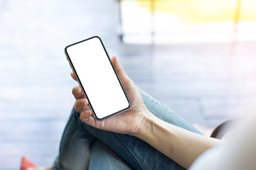 Mockup image blank white screen cell phone.woman hand holding texting using mobile at coffee shop.background empty space for advertise text.people contact marketing business,technology