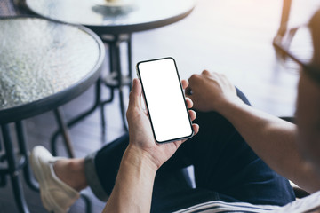 Mockup image blank white screen cell phone.man hand holding texting using mobile on desk at coffee shop.background empty space for advertise text.people contact marketing business,technology