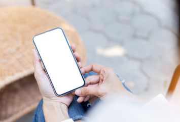 Mockup image blank white screen cell phone.woman hand holding texting using mobile on desk at coffee shop.background empty space for advertise text.people contact marketing business,technology