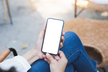 Mockup image blank white screen cell phone.woman hand holding texting using mobile on desk at coffee shop.background empty space for advertise text.people contact marketing business,technology