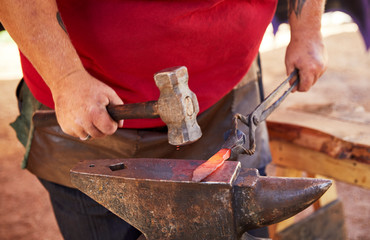 Blacksmith making a knife blade on an anvil