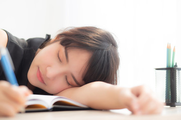 Beautiful portrait young asian woman smile and happy writing learning exam or homework and lying...