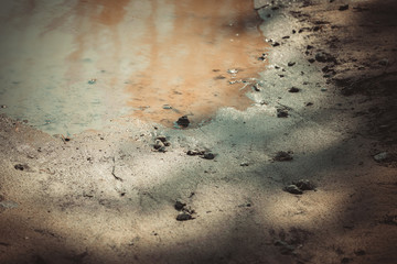 Deep spring puddle on the sandy road due to melting snow after winter.