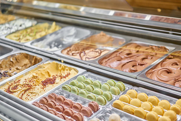 Assortment of colorful macaroons on cafe showcase. Variety of macaron flavours. Sweet almond cakes in store. Italian gelateria.