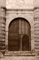 Sepia monochrome of an ancient door with stone archway in Essaouira Medina Morocco