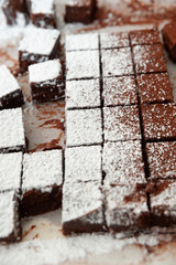 Delicious homemade raw chocolates cut into square shapes sprinkled with powdered sugar. Valentine's Day celebration. Vertical shot. Close-up.