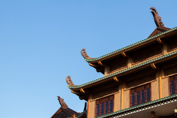 Fototapeta na wymiar chinese temple roof and windows with blue sky in the background