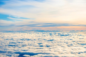 Aerial view of blue sunset sky with layers of white fluffy cumulus and cirrus clouds