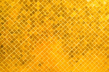 Closeup view of wall surface with many gold shiny mosaic squares. Саn be used as metallic...