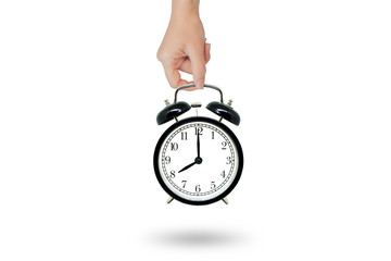 Time Management Concept : Female hand holding retro black alarm clock isolated on white background.