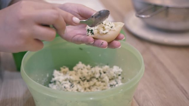 the girl hands puts the filling in the dough and it turns Italian ravioli