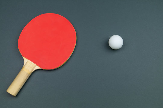 Red table tennis racket with a ball isolated on a colored background. sport equipment for ping pong