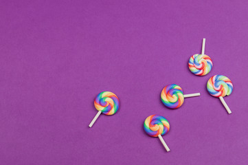 Colorful candies. lollipops isolated on purple background. festive concept. copy space
