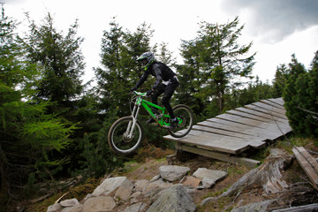 Fototapeta na wymiar Biker at mountain rocky peak landscape Bike Park Czarna Gora Poland