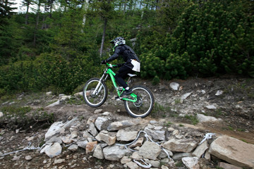 Fototapeta premium Biker at mountain rocky peak landscape Bike Park Czarna Gora Poland