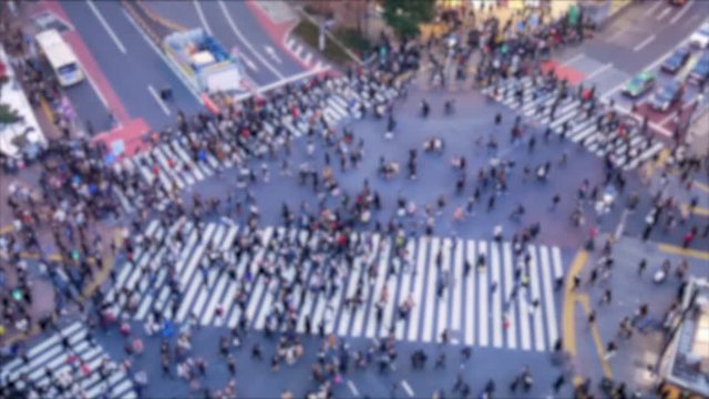 Blurred/Out of focusing technique view from above of people crossing road at Shibuya shopping street area. Famous japan tourist attraction in night time. People crossing the road in Tokyo Japan