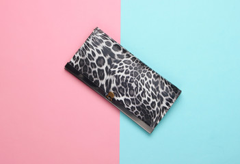 Stylish wallet on pink blue pastel background. Fashion minimalism. Top view