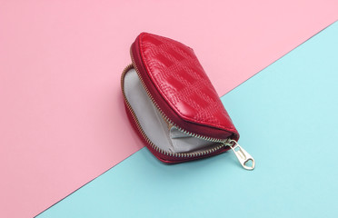 Red open wallet with zipper on a pink blue pastel background. Fashion minimalism