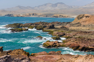 Rocky beach with  algaes and blue seawater at Huarmey´s seaside in Ancash region, Peru