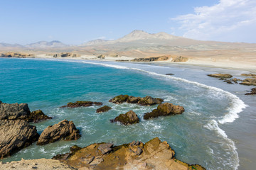 Fototapeta na wymiar Rocky beach with algaes and blue seawater at Huarmey´s seaside in Ancash region, Peru