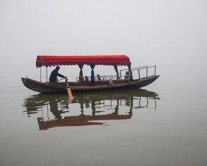 Fototapeta na wymiar Traditional chinese boat view in Wuhan city Donghu east lake during rainy season.