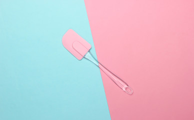Kitchen spatula on pink blue pastel background. Minimalism. Top view