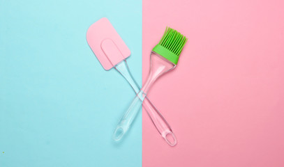 Kitchen tools. Kitchen spatula and brush on pink blue pastel background. Minimalism. Top view