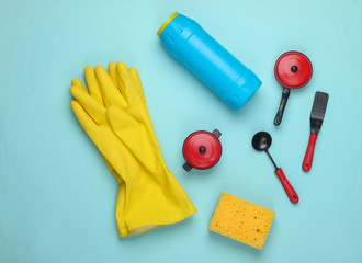Flat lay composition of dishwashing products, toy kitchen tools and utensils on blue background. Top view