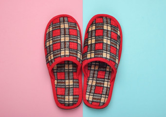 Checkered indoor slippers on a pink blue background. Top view