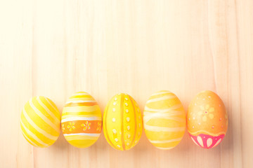 Happy Easter with colorful eggs at paintbrush for do it yourself on brown wooden floor top view with copy space